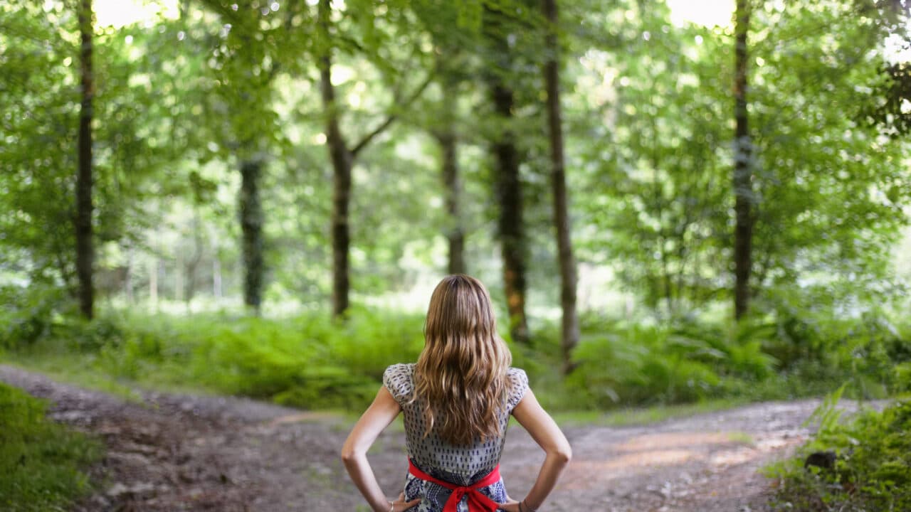 tjej gör val vid väg i skog